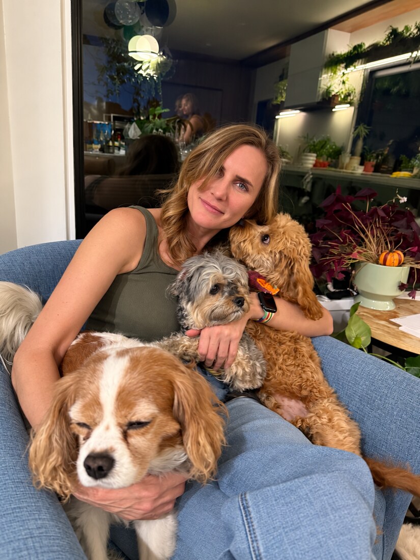 Haley sitting on a sofa with three dogs